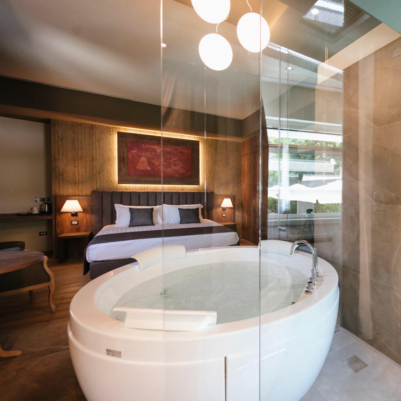 Camera d'albergo moderna con letto matrimoniale e vasca idromassaggio.