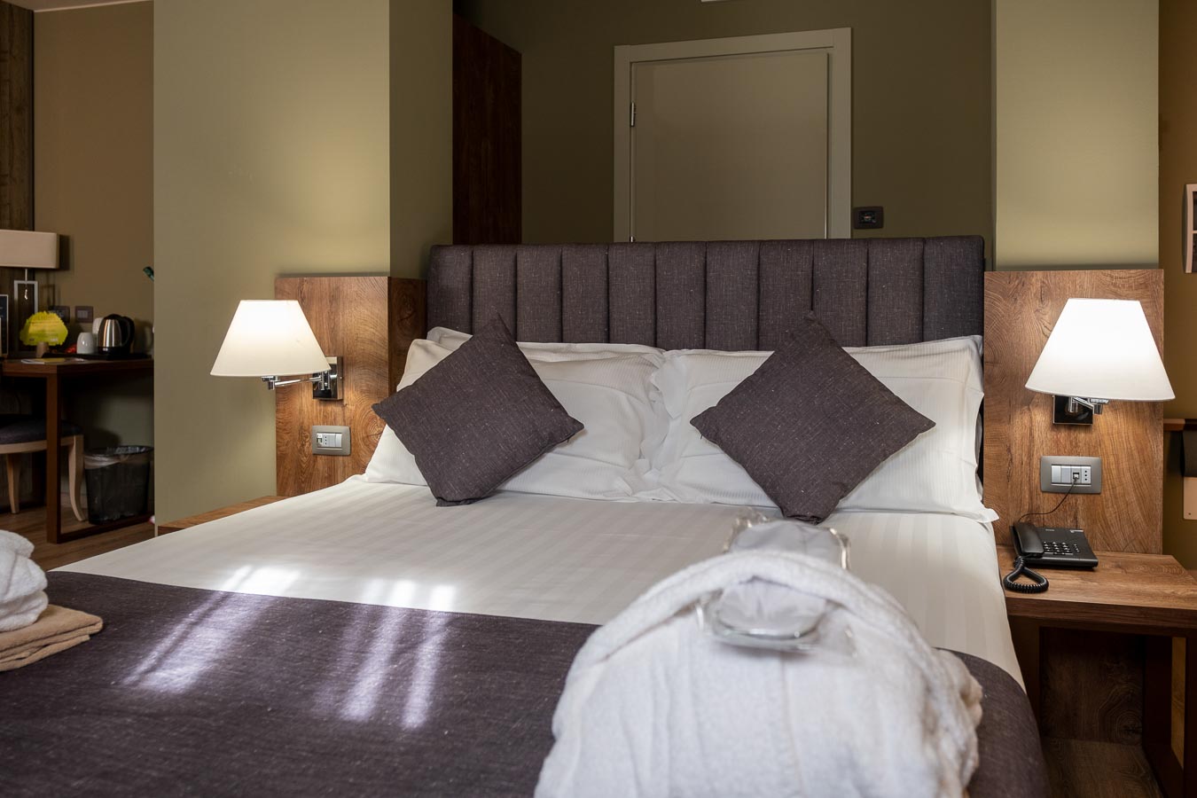 A cozy hotel room with a neatly made bed and bedside lamps.