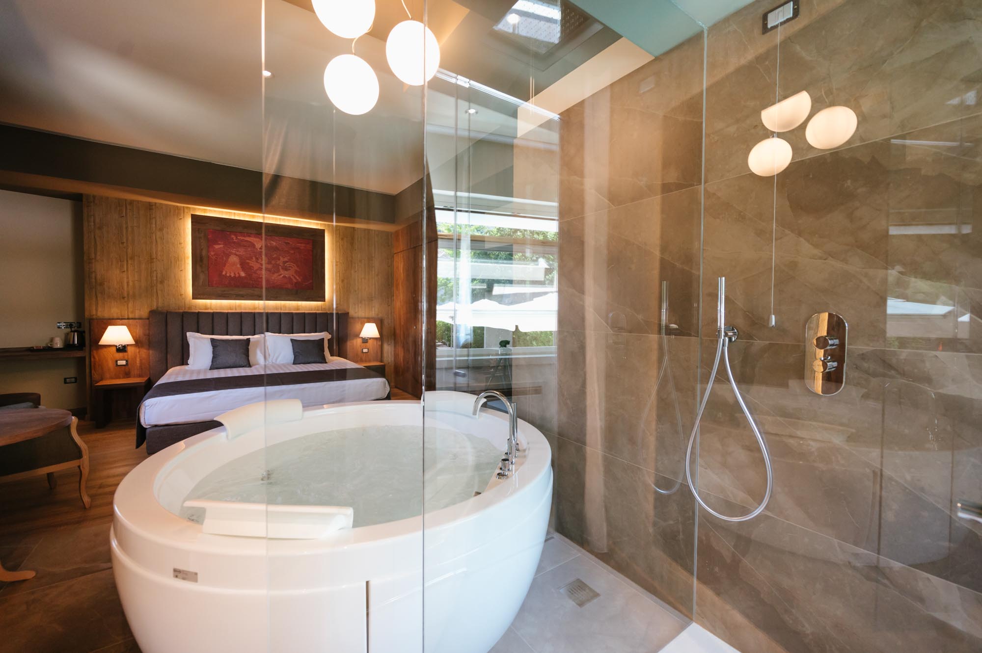 Camera da letto elegante con vasca idromassaggio e doccia in vetro.
