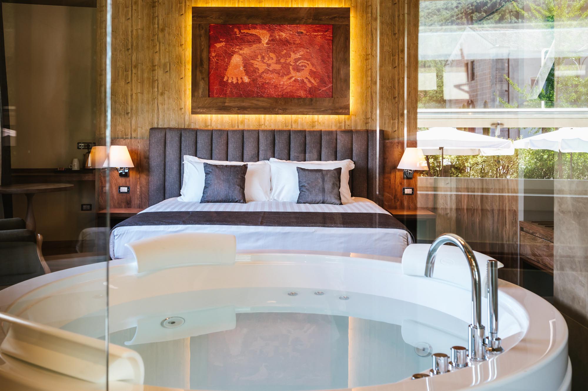 Camera d'hotel elegante con lettino e vasca idromassaggio in primo piano.