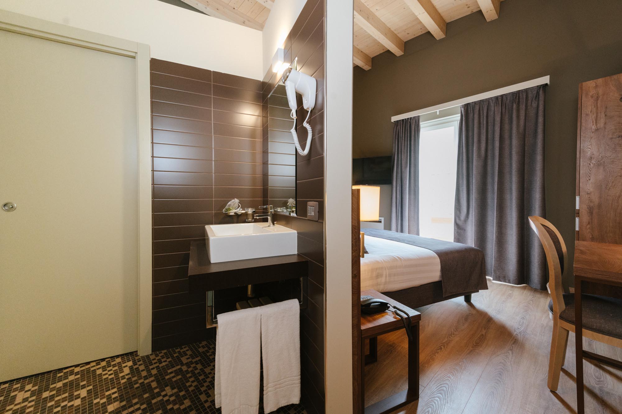 Interno di una camera d'albergo con bagno e zona notte separati.