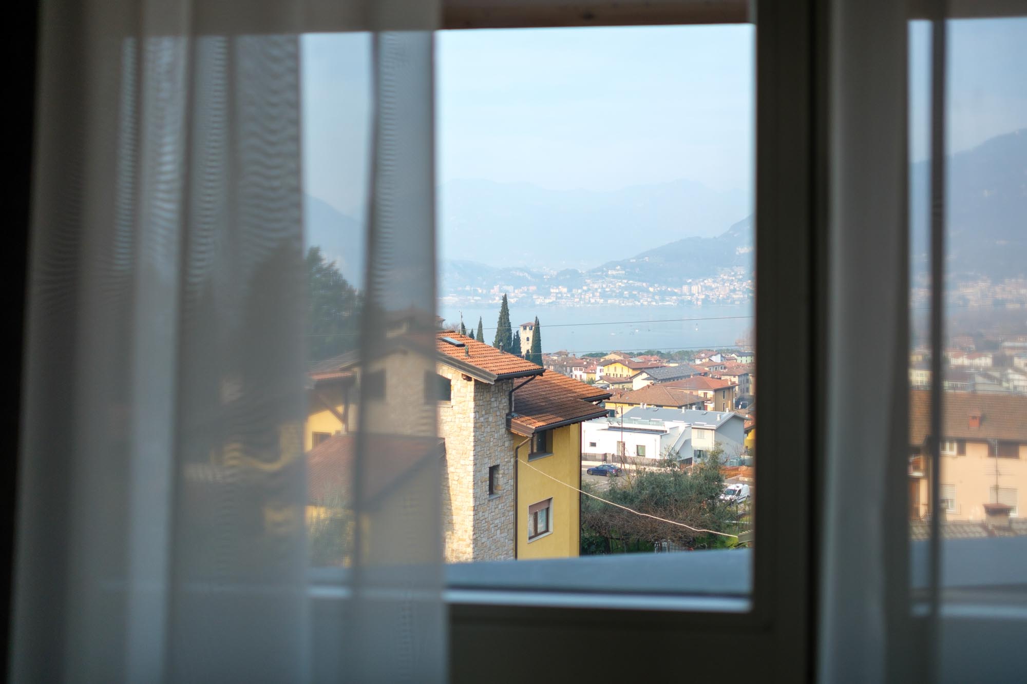 Vista di un villaggio e di un lago attraverso una finestra velata.