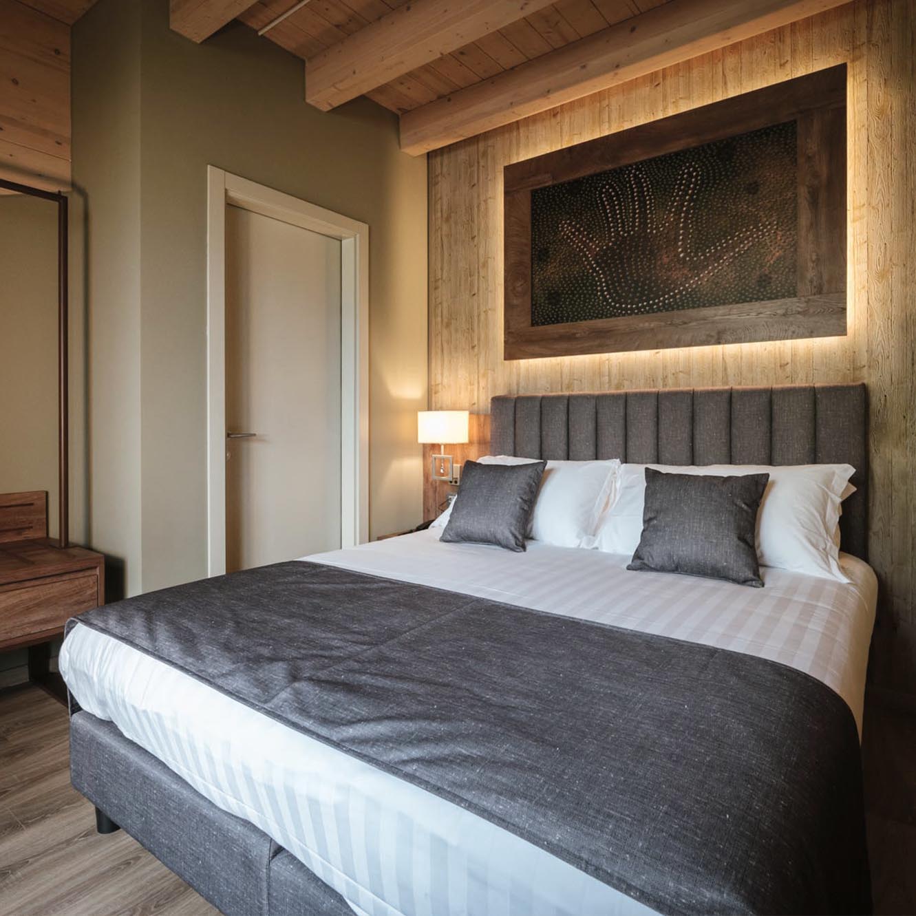 Camera da letto moderna con letto matrimoniale e decorazioni in legno.