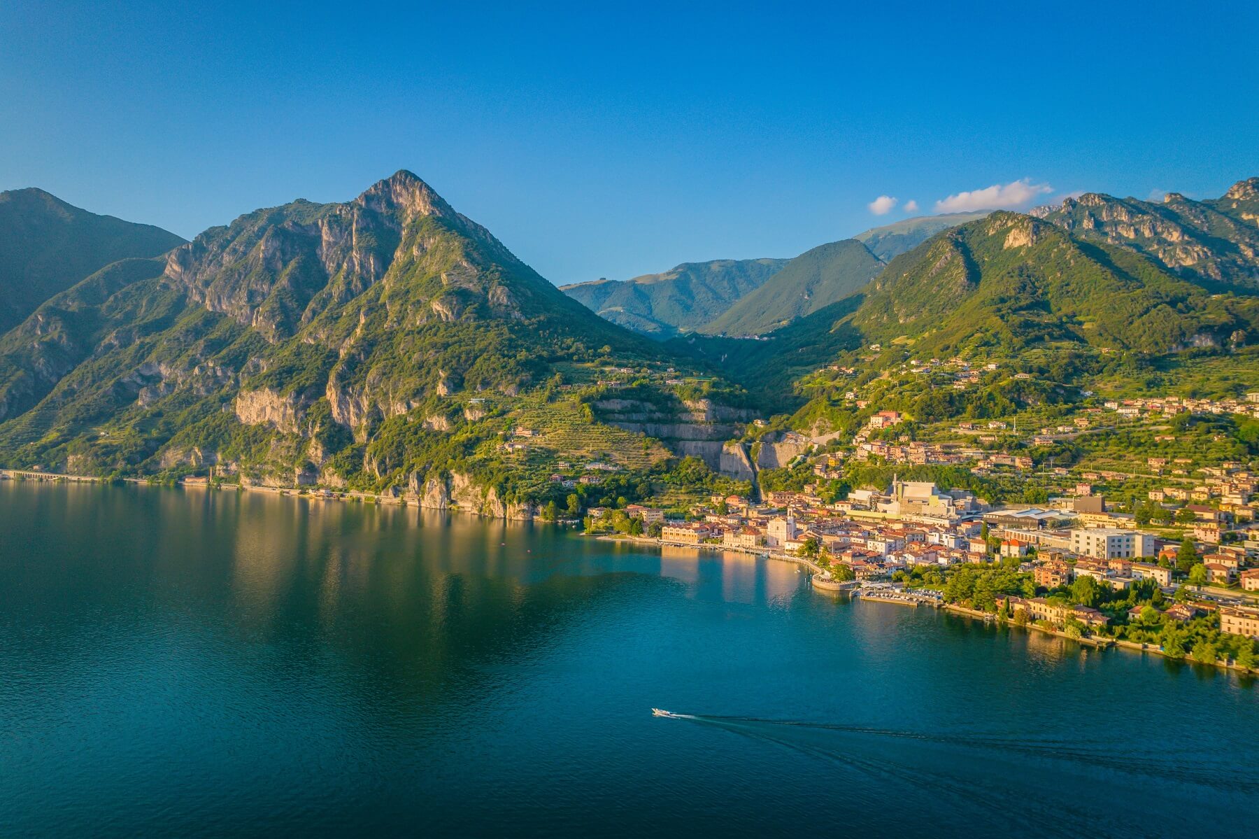 Vista panoramica di un lago circondato da montagne e un pittoresco villaggio.