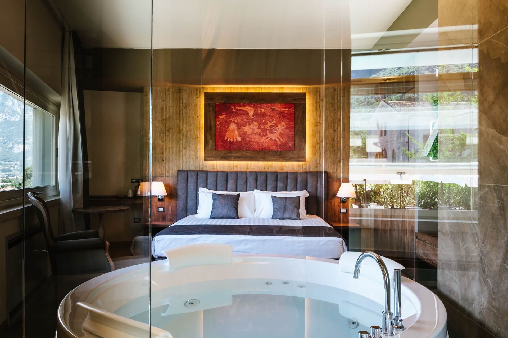 Camera d'hotel moderna con letto matrimoniale e vasca idromassaggio.